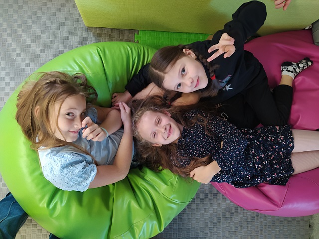 dziewczynki odpoczywają na różowej i zielonej pufie.jpg