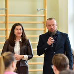 10. Kobieta i mężczyna stoją przed publicznością_ mężczyna przemawia przez mikrofon.jpg