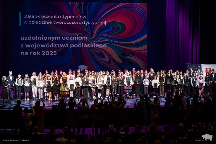 Duża grupa dzieci i młodzieży stoi na scenie..jpg