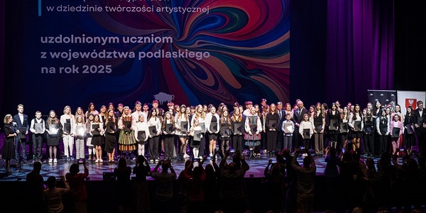 Duża grupa dzieci i młodzieży stoi na scenie..jpg