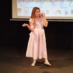 Dziewczynka na scenie odgrywa rolę Śnieżki_ trzyma w ręku jabłko..jpg