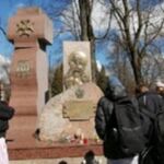Grupa uczniów stoi przy pomniku.jpg
