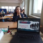 Widok ekranu laptopa na tle ucznia w słuchawkach.jpg