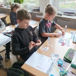 Dzieci wyklejają karty pracy w klasie..jpg