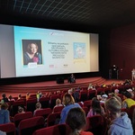Sala kinowa z wyświetlonym na ekranie zdjęciem kobiety.jpg