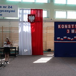 Dziewczynka gra na skrzypcach_ w tle flaga Polski oraz napis biało-czerwony na niebeiskim tle..JPG