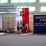 Poczet sztandarowy na tle flagi polskiej i granatowej tablicy z biało-czerwonymi napisami.JPG