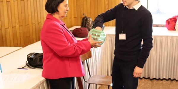 Uczeń losuje pytanie ze słoika trzymanego przez panią w czerownej marynarce..jpg