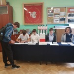 Pięciu chłopcówsiedzi przy granatowym stole.jpg