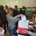 Uczennica wkłada kartkę do urny.jpg