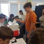 Uczeń wkłada kartkę do urny.jpg