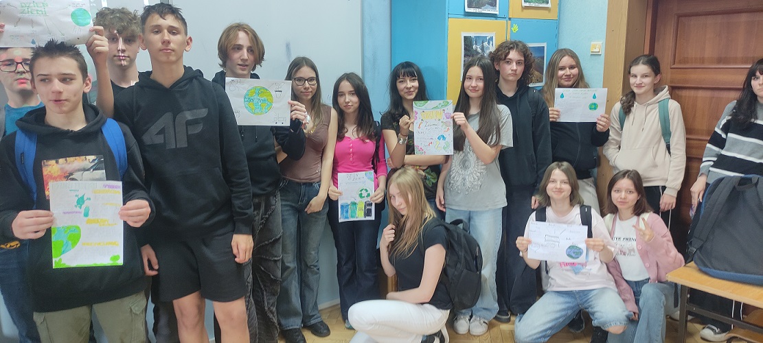Grupa uczniów pozuje do zdjęcia trzymają w rękach plakaty.jpg