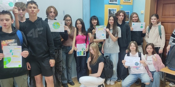 Grupa uczniów pozuje do zdjęcia trzymają w rękach plakaty.jpg
