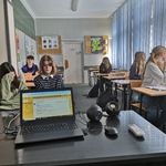 Grupa uczniów w klasie siedzi przed laptopem.jpg