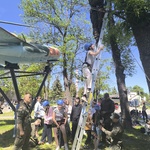 Grupa dzieci ubrana w kaski wspian sie po drabinie_ na której stoi żołnierz.jpg