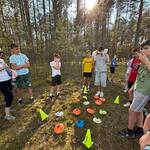 Chłopcy stoją przy kolorowych pionkach w lesie.jpg