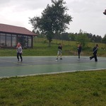Cztery osoby biegają w maskach po boisku.jpg