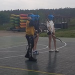 Troje dzieci stoi w maskach i z łukami.jpg