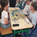 Dwóch chłopców siedzi przy stole z rozłożoną grą planszową..jpg