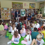 Pan dyrektor czyta uczniom_ którzy siedzą na podłodze na matach w bibliotece.jpg