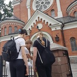 Trzy dziewczyny pochylają się nad kartką przy kościele..jpg