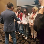 Mężczyzna wręcza medale osobom stojącym w rzędzie..jpg