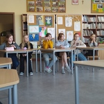 Grupa dziewczynek siedzi przy stolikach.jpg