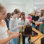 Grupa dziewczyn zaplata włosy na manekinach.jpg