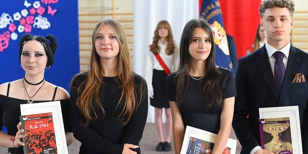 Trzy dziewczyny i chłopak elegancko ubarni pozują do zdjęcia..jpg