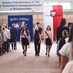 Poczet sztandarowy wychodzi z sali gimnastycznej. W tel flaga biało-czerwona..jpg