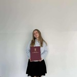 Dziewczyna pozuje do zdjęcia z dyplomem w ręku..jpg