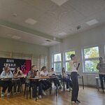 Grupa uczniów siedząca w ławkach_  jedna uczennica trzyma mazak w dłoni..jpg