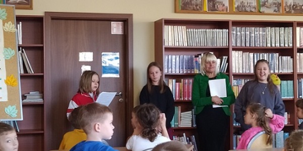 Dzieci słuchaja wierszy czytanych przez uczennicę w bibliotece szkolnej..jpg