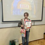Uczennica pozuje do zdjęcia z dyplomem i kolorową torebką..jpeg