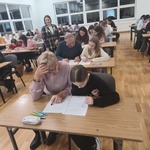 Rodzice z dziećmi piszą na kartkach w sali..jpg