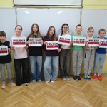 Grupa uczniów trzyma w rękach kartki z napisem Polska wolna..jpg