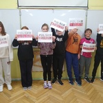 Grupa uczniów trzyma w rękach kartki z napisem Polska wolna.jpg