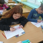 Troje uczniów wypełnia karty pracy.jpg