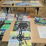 Na ławkach szkolnych ułożone są kolorowe prace konkursowe.jpg