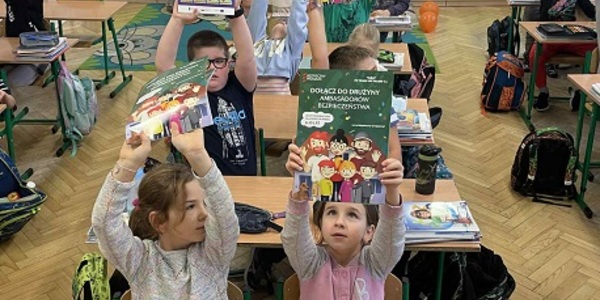 Dzieci w klasie trzymają w ekach w górze książeczki..jpg