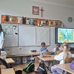 Grupa uczniów siedzi w ławkach w klasie i ogląda bajkę na monitorze.jpg