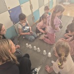Dzieci bawią się w klasie na podłodze białymi kubkami.jpg