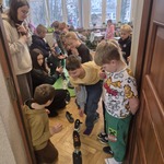 Grupa dzieci stoi przy butach ustawionych w rzędzie.jpg
