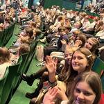 Widownia w kolorze zielonym wypełniona siedzącymi dziećmi..jpg