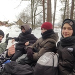 Grupa chłopaków ciepło ubranych siedzi na wozie w aurze zimowej..jpg
