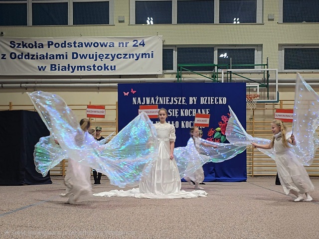 Grupa dzieci przebrana za aniołów tańczy.jpg