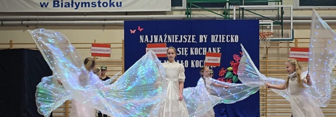 Grupa dzieci przebrana za aniołów tańczy.jpg