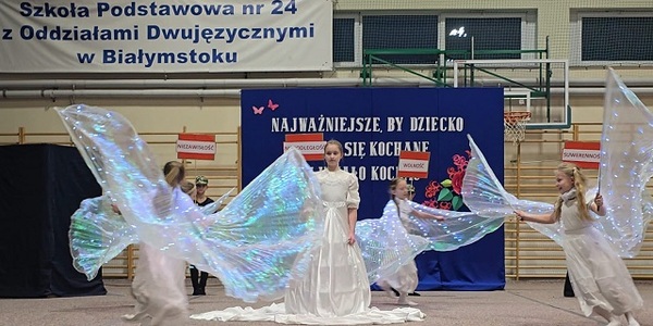 Grupa dzieci przebrana za aniołów tańczy.jpg