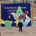 Grupa dzieci tańczy z falgami kolorowymi..jpg