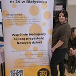 Kobieta stoi przy banerze.jpg